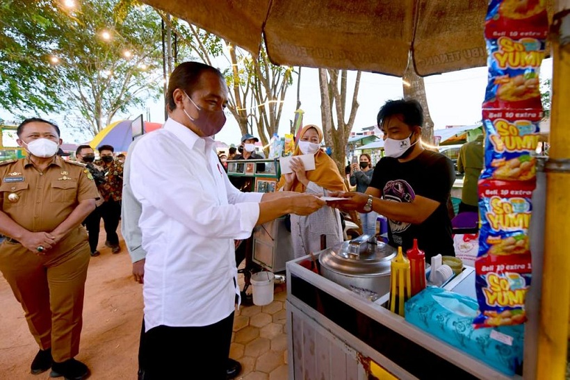 Presiden Jokowi menyerahkan bantuan tunai bagi para pedagang di Taman Batu 10 Kawasan Pasar Bintan Center, Kota Tanjung Pinang, Selasa (25/1/2022). Foto: BPMI Setpres